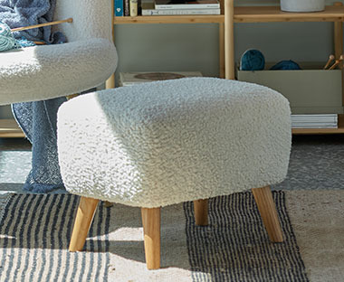 Off-white pouffe in fabric and solid wood legs